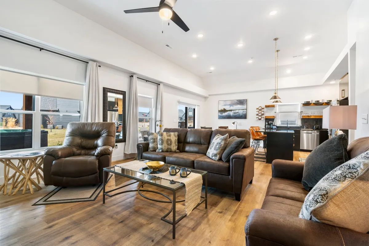 The image showcases a bright, open-concept living area with a plush seating arrangement and a stylish coffee table, seamlessly flowing into a sleek, modern kitchen. The inviting layout suggests a perfect setting for relaxing movie nights, lively gatherings, or intimate family meals.
